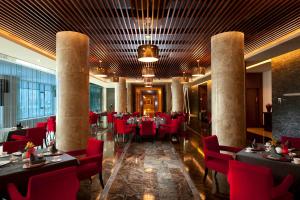 顺义北京首都机场希尔顿酒店的一间餐厅,房间内设有红色的椅子和桌子