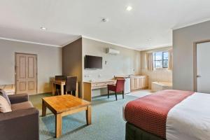本迪戈殖民品质酒店的酒店客房配有一张床、一张书桌和一间厨房。
