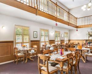 本迪戈殖民品质酒店的一间带桌椅的餐厅,以及楼梯