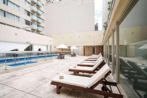 布宜诺斯艾利斯雷科莱塔眩晕酒店的一座带游泳池的建筑里一排躺椅