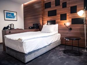 贝尔格莱德Best Western Premier Natalija Residence的一间卧室设有一张带木墙的大床