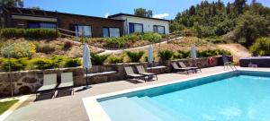 科维良Villa Regadio的一个带椅子的游泳池和一个背景房子