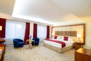 乌兰巴托汗宫凯宾斯基酒店的酒店客房,配有一张床和两张蓝色椅子