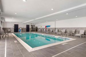 克拉克斯维尔Comfort Inn & Suites的一座配有桌椅的酒店游泳池