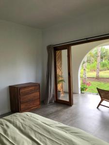 巴图卡拉Rumah Markisa Batukaras的一间卧室配有一张床、一个梳妆台和一扇窗户。
