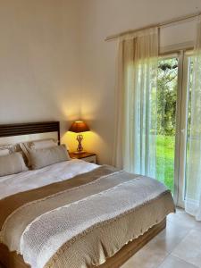 斯卡拉拉乔伊Olive Dream Thassos Luxury Villas的一间卧室设有一张床和一个大窗户