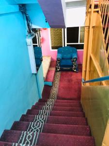 坎大哈Millat Hotel & Noor Jahan Hotel Kandahar的一间蓝色椅子的房间,有一段楼梯