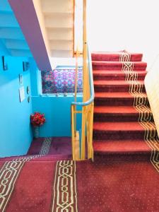 坎大哈Millat Hotel & Noor Jahan Hotel Kandahar的一座铺有红地毯的建筑的楼梯