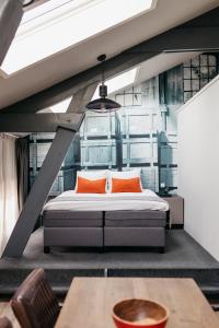 阿姆斯特丹YAYS Amsterdam Maritime by Numa的一间卧室配有带橙色枕头和桌子的床