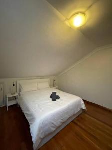 悉尼Comfortable 3 Bedroom House Pyrmont的卧室配有白色的床和帽子