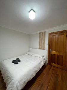 悉尼Comfortable 3 Bedroom House Pyrmont的卧室配有白色的床和木门
