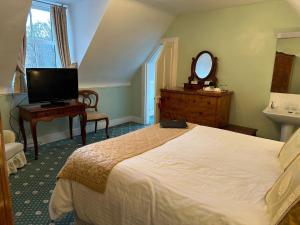 斯佩河畔格兰敦Ravenscourt House, Guest House & Restaurant的一间卧室配有床、水槽和镜子