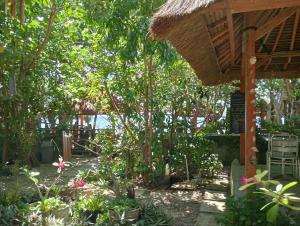 瑟克通Pelangi Homestay Bungalow Gili gede的一个带凉亭和一些植物的花园