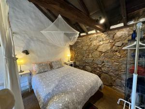 上布雷尼亚Finca La Principal的一间卧室设有一张床和石墙