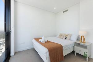 悉尼St Leonards 2B2B Apt with Skyview的白色的卧室设有床和窗户