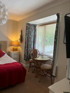 韦德布里奇Gwynarth Guest House的一间卧室配有桌椅和窗户。