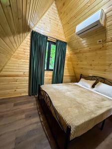 GachediliMartvili canyon cottage的木制客房内的一间卧室,配有一张床