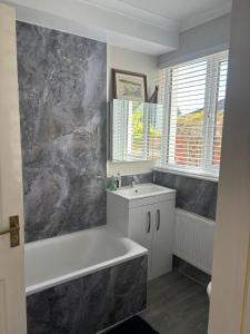 韦德布里奇Gwynarth Guest House的带浴缸和盥洗盆的浴室