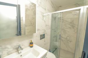 伊兹密尔Sulty's Alaçatı的带淋浴、盥洗盆和镜子的浴室