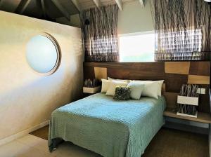 Jolly HarbourCasa frente al mar en Antigua的卧室配有一张壁挂镜子的床