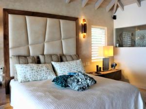 Jolly HarbourCasa frente al mar en Antigua的卧室配有一张大白色的床和大床头板