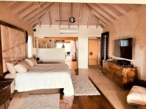 Jolly HarbourCasa frente al mar en Antigua的一间卧室配有一张床和一台平面电视