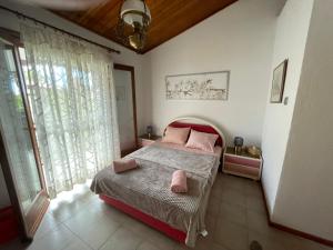 耶拉基尼Superior Maisonette, Trikorfo Beach, Gerakini, Chalkidiki的一间卧室配有带粉红色枕头的床。