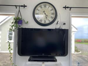 斯莱戈Wild Atlantic cabin的上方墙上有带时钟的电视