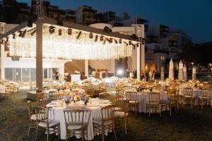 雅丽丝弗里克巴巴洛斯湾博德鲁姆凯宾斯基酒店的婚礼招待会,配有白色的桌椅和灯光