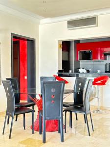 阿加迪尔Fabulous Apartment in Marina Agadir的一间设有玻璃桌和黑色椅子的用餐室