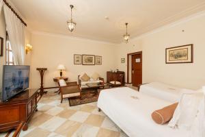 新德里新德里帝国酒店的一间卧室设有一张床和一台电视,还设有一间客厅。