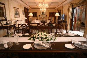 新德里新德里帝国酒店的用餐室,配有带盘子和鲜花的桌子