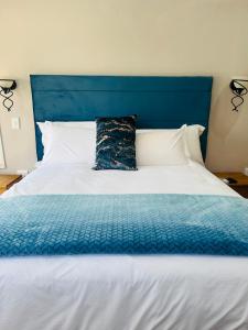 MogwaseMeLeano Guesthouse的蓝色和白色的床,带有蓝色床头板