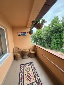 奥尔绍瓦Casa RoxAmy的阳台配有地毯、藤椅和窗户。