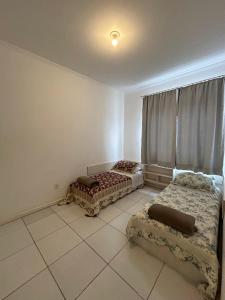 拉热斯Apto em ótima localização!的客房铺有瓷砖地板,配有两张床。
