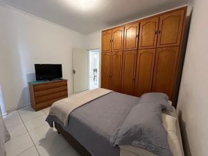 拉热斯Apto em ótima localização!的一间卧室配有一张床和一台平面电视
