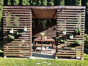 桑多梅日Lawendowo- sauna jacuzzi domki w ogrodzie i apartamenty w kamienicy的木栅,带桌子和盆栽植物