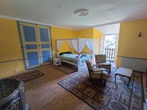 MontégutChateau Montegut的一间卧室配有床,另一间卧室拥有黄色的墙壁