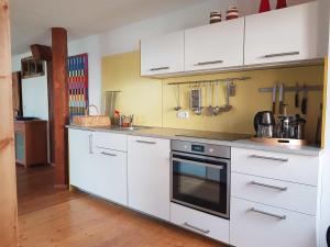 派廷格Ferienwohnung Hofen 5的厨房配有白色橱柜和炉灶烤箱。