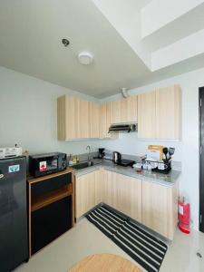 伊洛伊洛WV 4 Urban Studio的厨房配有木制橱柜和黑色冰箱。