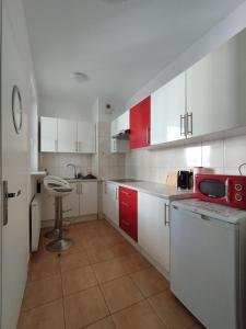 华沙Villa Natali Warszawa的厨房配有红色和白色的橱柜和红色微波炉