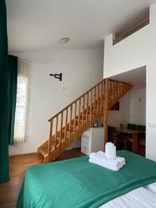 塞济斯菲厄泽梅迪亚卢纳旅馆的一间卧室设有一张绿色的床和一个楼梯。