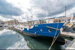 伦敦Historic Dutch Barge, Idyllic location的停靠在码头的蓝白船