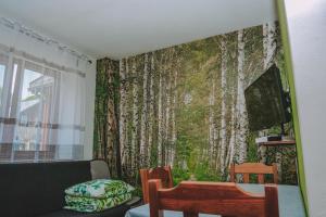 卢巴夫卡Noclegi nad Zalewem Bukówka的客厅配有壁画树木