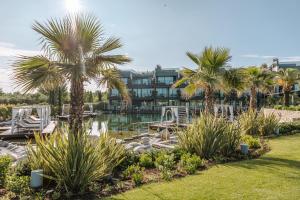 拉齐塞Quellenhof Luxury Resort Lazise的棕榈树和水体的度假胜地