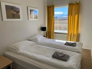 BærThe Hvítá Inn的一间卧室配有一张带黄色窗帘的床和一扇窗户
