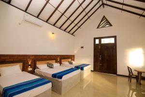 阿努拉德普勒Ari Guest House的一间卧室设有两张床、一张桌子和一扇门
