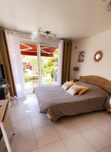 卢恰纳Chambre d'hôte Kalango proche de la plage-Piscine的一间卧室设有一张床和一个滑动玻璃门