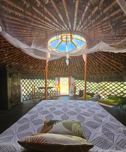 拉梅特拉·德·玛尔Yurta Bora Bora的一间位于稻草小屋的卧室,配有一张大床