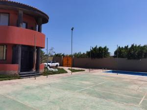 伯格埃拉伯Villa Mostafa Sadek, Swimming pool, Tennis & Squash - Borg ElArab Airport Alexandria的大楼旁停车场的网球场